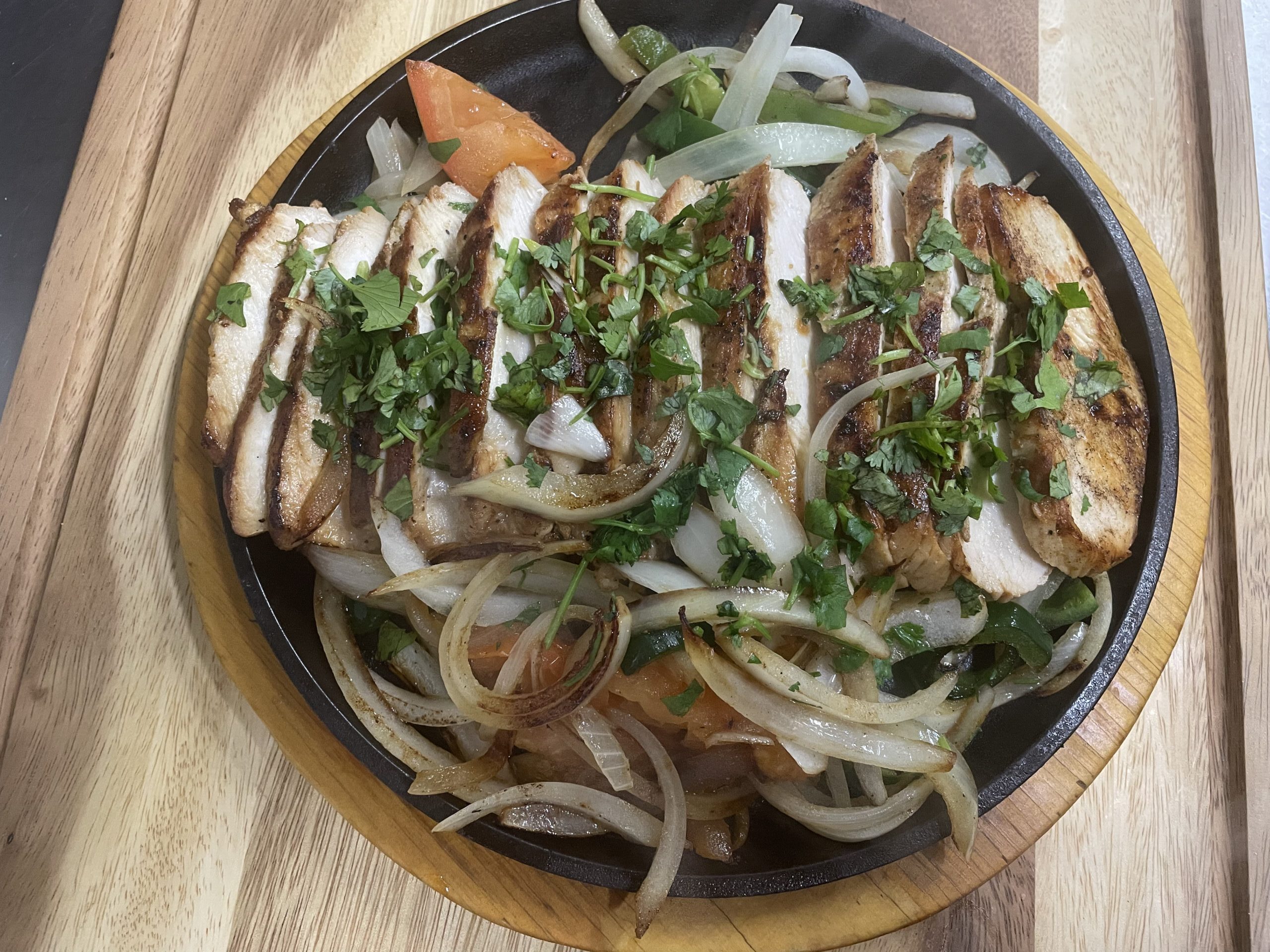 Chicken fajitas sizzling with onions and peppers at Anita's Tex-Mex